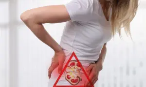 Kobieta trzyma się za bolący bok, gdzie widoczny jest przekrój nerki z czerwonym ostrzeżeniem. Może to symbolizować skurcz nerki.